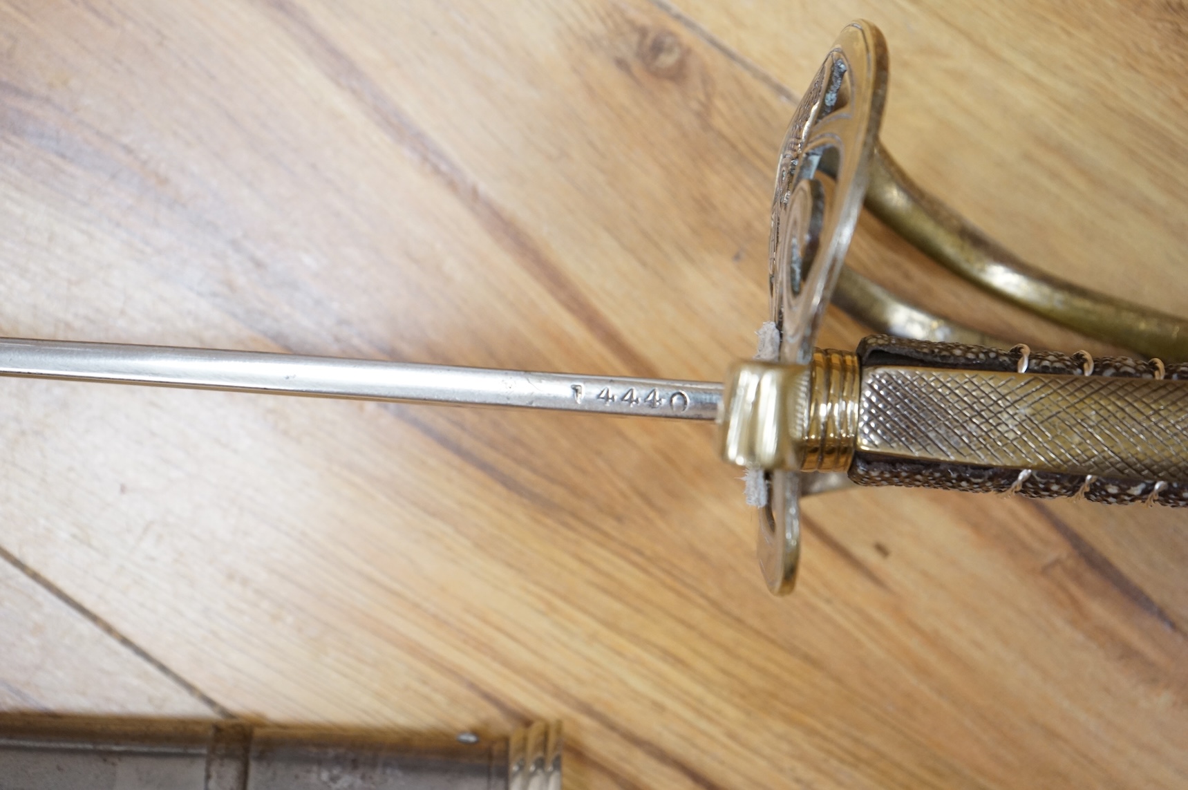 A post 1902, 1827 pattern Rifle Brigade officer’s dress sword, with regulation blade with traces of edge decoration, regulation nickel guard with crown strung bugle and wire bound fish skin covered grip, in its steel sca
